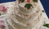 A four-tier wedding cake, looks like chocolate and coconut flavour.