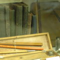 A number of old books and some writing instruments.