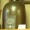 Brown jug with sign: If whiskey interferes with your business, give up your business.