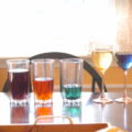 Several glasses of liquids in various colours.