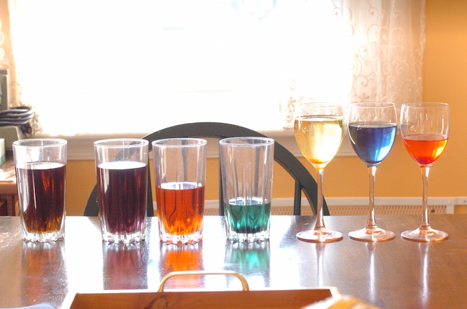 Several glasses of liquids in various colours.