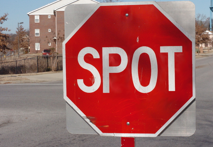 Stop sign that reads SPOT.